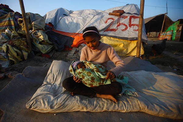 11 year old Ambika Giri takes care of her 27 day old cousin Dilip Nepali at a makeshift shelter in Chuchepati on Monday. With dipping temperature, earthquake survivors like Giri and her cousin are facing a hard time without proper shelter and warm clothes.