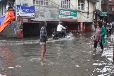 KEEP WALKING: Pedestrians cross a flooded road in Teku on Wednesday.
