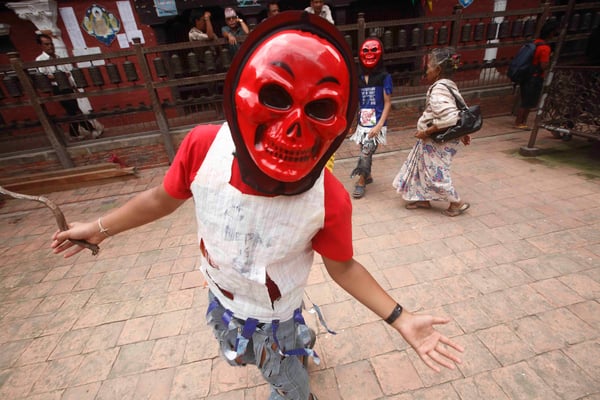 Masked devotees take part in a parade observing the ancient Neku Jatra-Mataya festival, or the festival of lights in Patan on Tuesday.