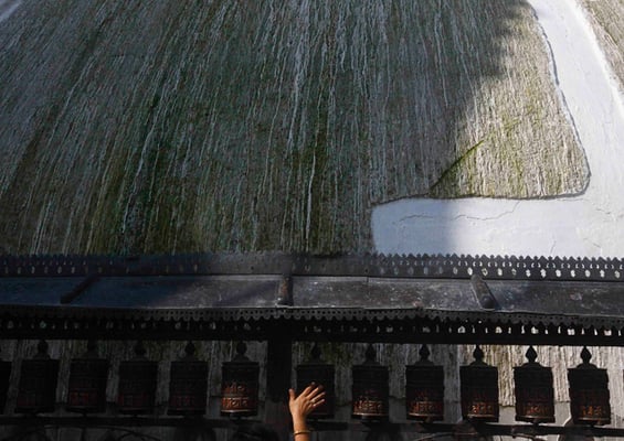The hand of a devotee is seen spinning the prayer wheels at Swayambhunath Stupa on Monday.