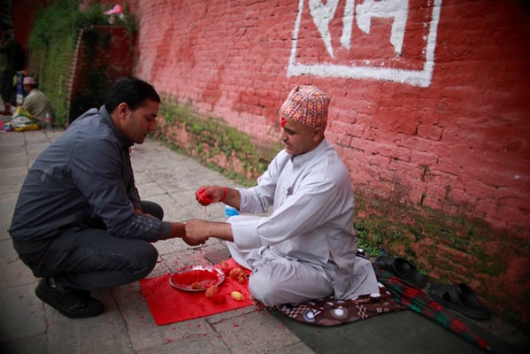A Hindu priest ties the sacred thread around the wrist of a man on the occasion of Janai Purnima at Pashupati on Thursday.