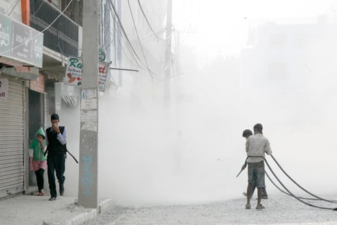 RUN: Pedestrians hurry past a cloud of dust on the Baneswor road as workers prepare it to be blacktopped, on Thursday at Old Baneswor.