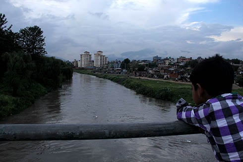 RISING RIVER: A boy stops by Teku to look at the swollen Bagmati river after the evening downpour on Friday.