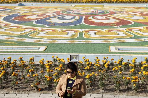 A woman tries to take a selfie in front of Maitighar Mandala on Saturday.