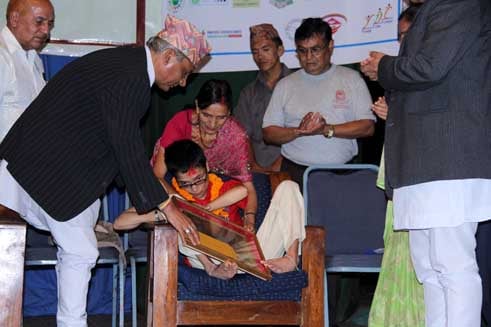 YOUNG WORLD: Chairman of the Interim Council of Ministers Khil Raj Regmi felicitates writer Jhamak Ghimire at Nepal Academy on the occasion 14th International Youth Day on Monday.