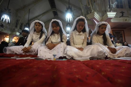 A group of girls read out their prayers during an Easter function organised at the Catholic church in Dhobighat on Saturday.