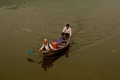 HEAVY LOAD: Salesmen transport a gas cylinder across Phewa Lake to hotels in Pokhara.