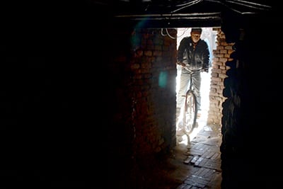 INTO THE ABYSS: A man enters a dark and narrow alley on his cycle near Patan Dhoka on Monday.