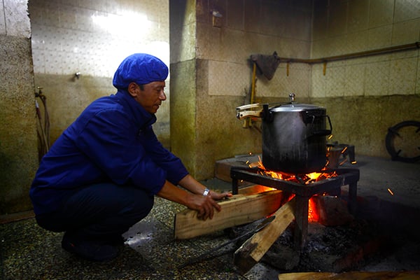 39-year-old Yubhan Tamang cooks food using fuelwood for patients in Bir Hospital on Tuesday. The kitchen at Bir Hospital has been cooking with firewood for the past one and a half months and serving food to around 300 patients daily.