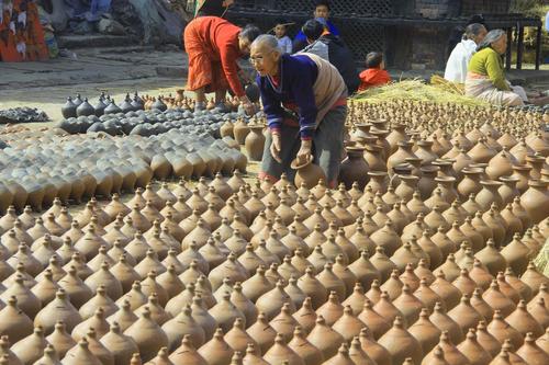 A potter dries clay pots in the sun at Bhaktapur on Sunday.