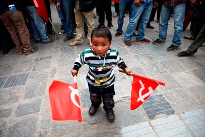 YOUNG FOLLOWER: A boy holds flags of UCPN-Maoist during the 18th anniversary of decade-long Maoist insurgency at Basantapur on Tuesday.