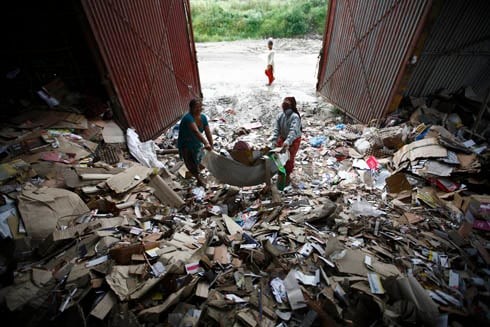 WASTE NOT: Women collect waste paper at Teku on Tuesday. The paper is then sold to recycling plants.