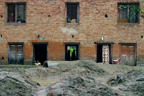 A child waits inside a house during a downpour in the valley on Tuesday.