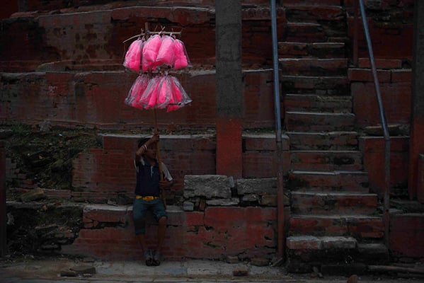 A boy sells cotton candy below one of the collapsed temples at the Basantapur Darbar Square on Thursday.