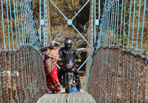 EXCUSE ME: A bike rides past pedestrians over the suspension bridge in Samundratar, Nuwakot on Thursday.