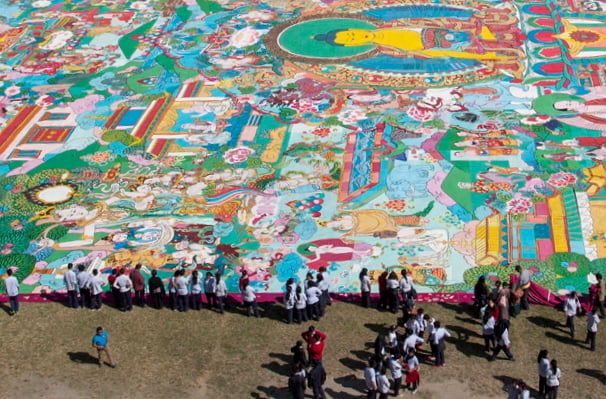 Students take a look at a thanka painting, considered to be the world's largest thangka, at Dasarath Stadium in Kathmandu on Friday. Measuring 70 metres by 50 metres, the artwork was created by stitching 81 different pieces of fabric.