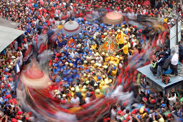 Devotees adorned in colorful caps participate during the chariot festival of Kankeshwori, Bhadrakali and Sankata at Asan in Kathmandu on Tuesday.