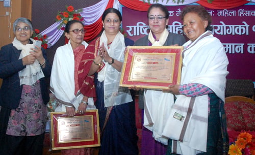 National Women Commission felicitates Dil Sobha Shrestha of Aama Ghar (right) on its 14th anniversary in Kathmandu on Sunday.
