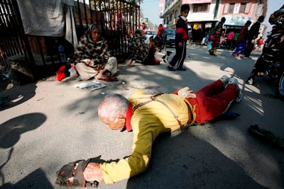 STEPS FORWARD: A Buddhist pilgrim from Tibet prostrates flat on the ground and chants mantras in Swayambhunath Temple on Sunday.