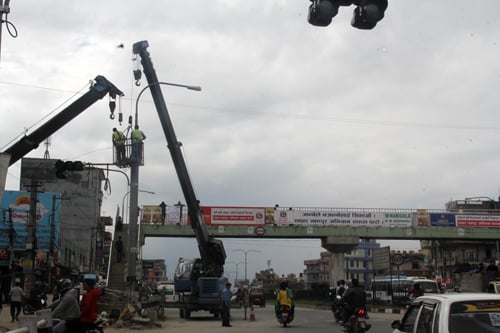Workers install solar-powered street lights at Lokhanthali ahead of November's SAARC Summit on Monday.