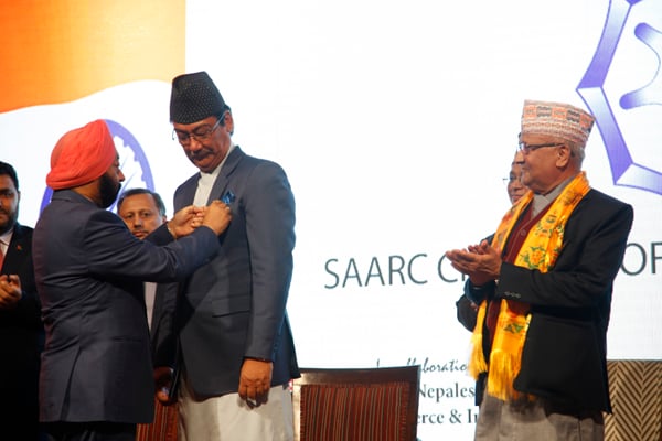 Businessman Suraj Vaidya receives the SAARC Chamber of Commerce and Industry (CCI) pin from Past President Vikramjit Singh Sahney at an event attended by Prime Minister KP Oli in Kathmandu on Monday.