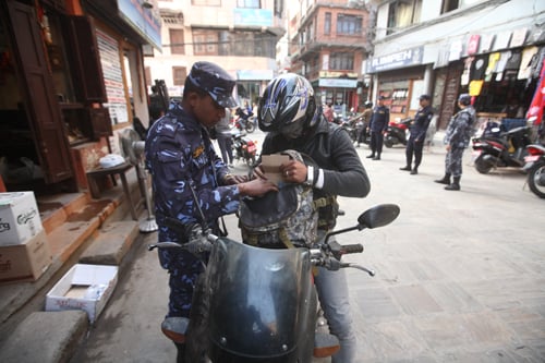 A policeman checks the bag of a motorcyclist at New Road on Monday. Such security checks are getting more common closer to the SAARC summit.