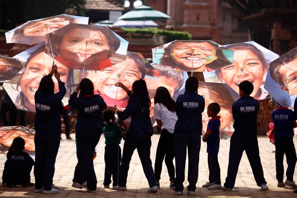 A group of school children hold umbrellas during as event to make people aware about the status of the heritage sites in Bhaktapur Durbar Square on Friday.