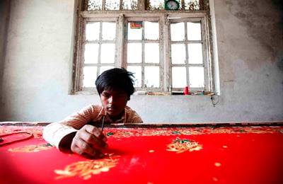 EARNING A LIFE: An Indian migrant boy works in a sari factory at Thankot on Wednesday.
