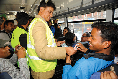 PART-TIMER: Haribansha Acharya collects tickets from passengers during the inauguration of Shajha Yatayat bus service in Kathmandu on Saturday.