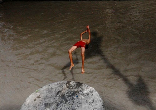 A young boy dives in Bagmati river at Pashupati to beat the summer heat on Monday.
