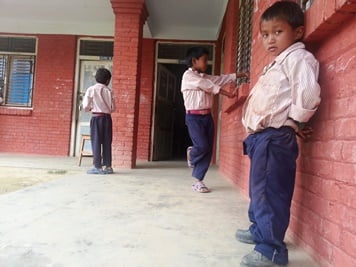 LOS THREE AMIGOS: Kids wait for their teacher to come to class in Rabiopi, Kavre, early on Sunday.