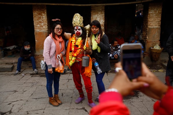 Devotees pose for a photograph with a holy man dressed as Hanuman, the monkey god at Pashupati during Maha Shivaratri festival on Tuesday.