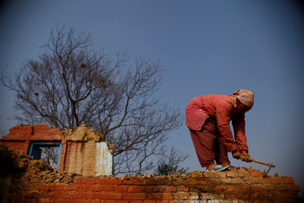 34-year-old Binita Bhujel works to demolish a house, brick by brick, in Chapagaon on Thursday.